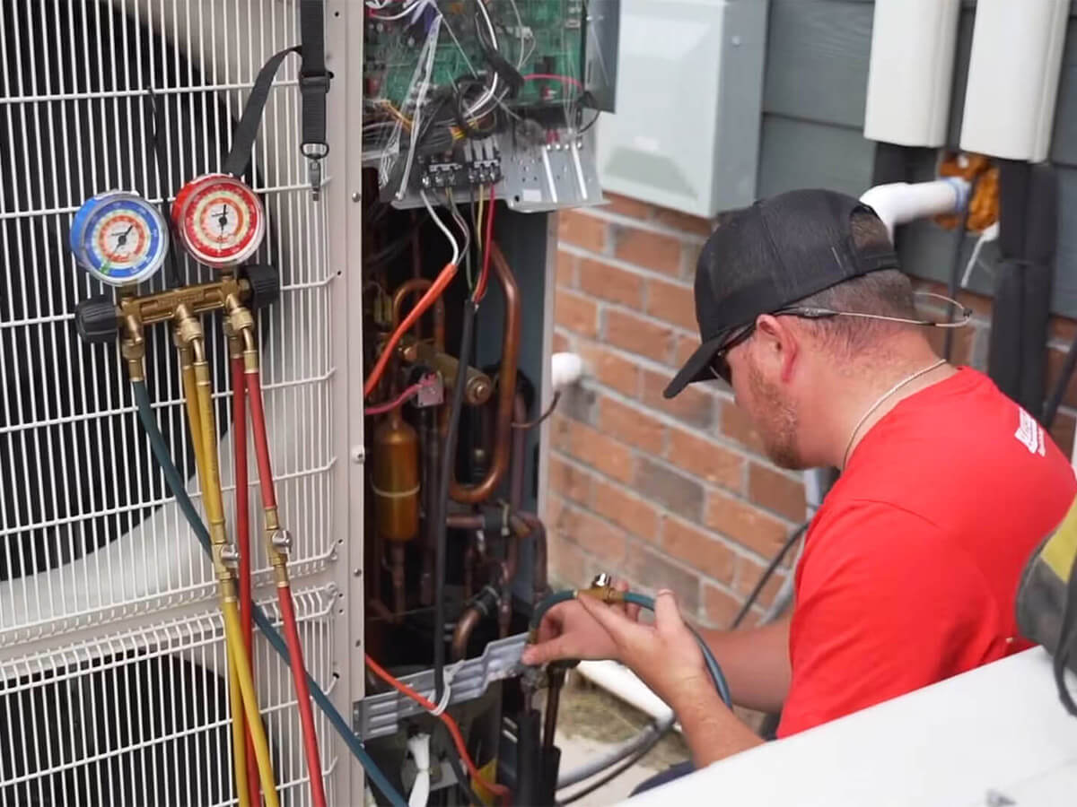 a technician from hatfield heating and air working on a HVAC unit